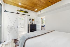 a bedroom with a white bed and a wooden ceiling at Tree Farm Sanctuary in Basalt