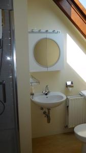 ein Bad mit einem Waschbecken und einem Wandspiegel in der Unterkunft B&B Dreamcottage in Knokke-Heist