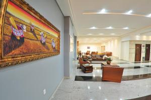 a living room with a large painting on the wall at Turis Hotel in Passo Fundo