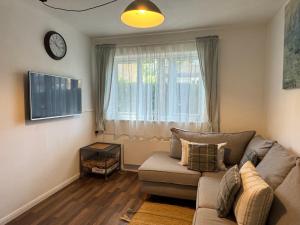 a living room with a couch and a window at Grundy House in Uxbridge
