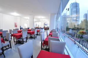 a restaurant with red and white tables and chairs at Turis Hotel in Passo Fundo