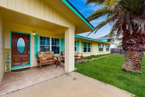 a house with a porch with a chair and a table at Palm Breeze Family Getaway in Rockport