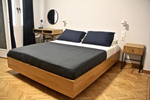 a bedroom with a bed with blue pillows and a desk at Apollo & Nike 1952-2025 in Athens
