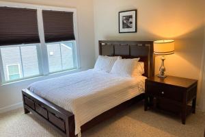 a bedroom with a bed and a lamp and two windows at Grande at Canal Pointe --- 37546 Worcester Dr. in Rehoboth Beach +30 photos