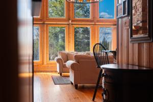a living room with a couch and some windows at Fiddler Lake Resort - Deer 86 in Mille-Isles
