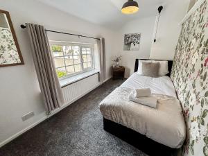 a bedroom with a bed and a window at Yellow House Cottage in Southport