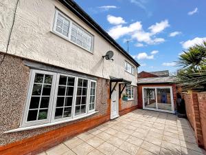 a house with a large window and a driveway at Yellow House Cottage in Southport