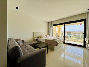um quarto com uma cama, um sofá e uma cama em Cozy Studio Apt @ G-cribs El Gouna with a View. em Hurghada