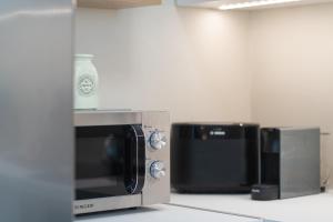 a microwave oven with a bottle on top of it at Kymvari - Stunning sea view-elegant apt-infinity shared pool in Kalyves