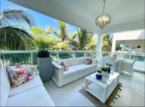 a living room with white furniture and palm trees at Beautiful Two bedrooms apartment in Punta Cana