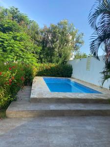 a swimming pool in a garden with stairs and flowers at Beautiful Two bedrooms apartment in Punta Cana +3 photos