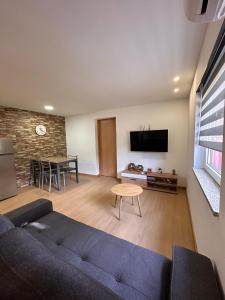 a living room with a blue couch and a table at Chalé da Fonte - T2 in Geres