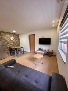 a living room with a blue couch and a table at Chalé da Fonte - T2 in Geres