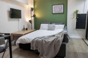 une chambre avec un lit et un mur végétal dans l'établissement The City Nest, à Manchester