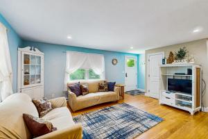 a living room with a couch and a tv at Winthrop Cottage in Oak Bluffs