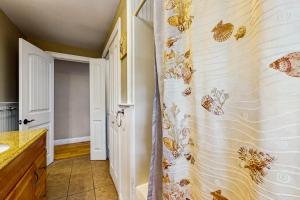 a bathroom with a shower curtain with butterflies on the wall at Winthrop Cottage in Oak Bluffs +13 photos