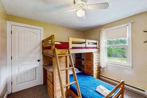 a bedroom with bunk beds and a ceiling fan at Winthrop Cottage in Oak Bluffs