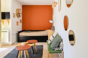 a small room with a bed and a table and chairs at L'Océanaise in Soulac-sur-Mer