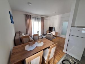 a kitchen and living room with a table and a refrigerator at Apartman IGOR Trebinje in Trebinje