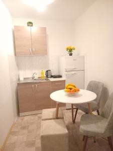 a kitchen with a table with a bowl of fruit on it at Apartmani Tarik in Mostar