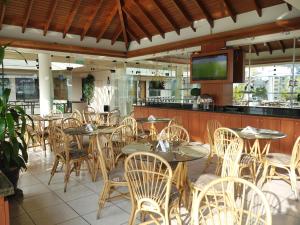 a restaurant with tables and chairs and a television at Hotel Boulevard in Lima