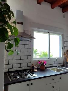 a kitchen with a stove and a sink and a window at Vivaldi Summer in Icod de los Vinos +29 photos