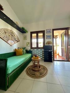 a living room with a green couch and a table at Sea&Sage 4 Spiagge Raggiungibili a piedi, Per famiglie con tutti i servizi in Porto San Paolo