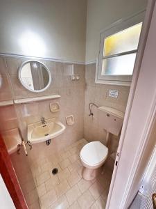 Un baño con inodoro, lavabo y espejo. en Villa Theodora, en Kerion