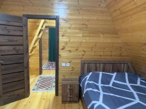 a bedroom with a bed in a log cabin at Dream house in Nikortsminda