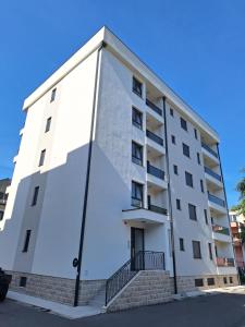 a white apartment building with stairs in front of it at Apartman IGOR Trebinje in Trebinje