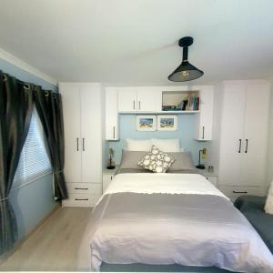 a bedroom with a large white bed and a window at Sunset Haven Ocean, Mountain & Valley Views in Cape Town +67 photos