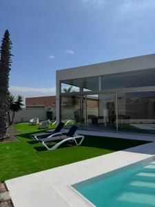 a house with two lounge chairs and a swimming pool at Villa Atlantic Breeze in Antigua