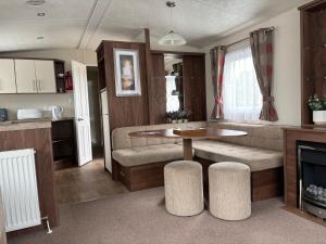 a kitchen and living room with a table in a caravan at The Bay Pearl 2 Bedroom Elegant Pet Free Stay at Clarach in Aberystwyth