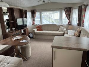 a living room with a couch and a table at The Bay Pearl 2 Bedroom Elegant Pet Free Stay at Clarach in Aberystwyth