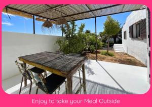 an image of a wooden table on a patio at Full Relaxation - Private Villa - Sea View - Stunning Garden - 2 Terraces - 2 Bedrooms - Wifi - Parking - Washing Machine in Güime