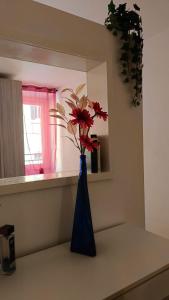 a blue vase with a red flower in a window at La Casa Del Vino - Marino Centro in Marino
