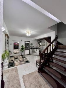 Un gran salón con escaleras y una cocina. en Casa Daiana, en Ocna Şugatag