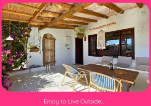 a living room with a wooden table and chairs at Full Relaxation - Private Villa - Sea View - Stunning Garden - 2 Terraces - 2 Bedrooms - Wifi - Parking - Washing Machine in Güime