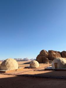 a group of domes in a desert with rocks at Kadi Wadi Rum in Al Jafr