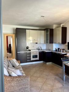 Casa Tempesti في سان فينتْشينسو: غرفة معيشة مع أريكة ومطبخ +صورتان