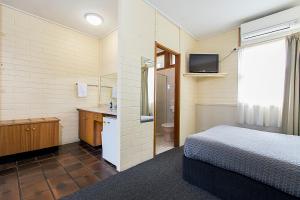 
a hotel room with a bed and a tv at Citrus Valley Motel in Renmark
