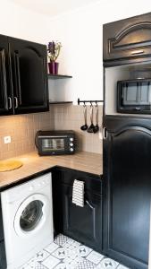 eine Küche mit Waschmaschine und Mikrowelle in der Unterkunft T2 Cosy centre ville proche gare in Tourcoing + 2 Fotos