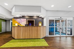 an office lobby with a reception desk and large windows at Spark by Hilton Wilkes Barre in Wilkes-Barre