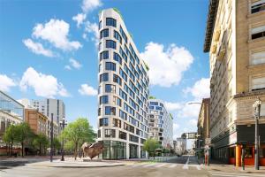 旧金山Timbri Hotel San Francisco, Curio Collection by Hilton的城市街道上一座有牛雕像的建筑