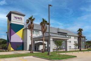 a hotel with palm trees in front of a building at Spark by Hilton Hammond in Hammond