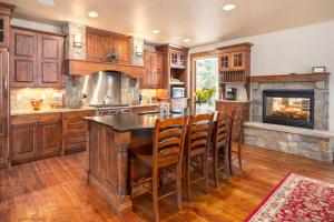 cocina grande con armarios de madera y chimenea en Base Camp 490 Private Hot Tub, en Winter Park
