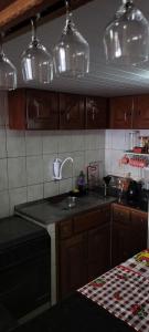 cocina con armarios de madera, fregadero y encimera en Apartamento ideal para famílias em mosqueiro, com piscinas e em frente a praia, en Mosqueiro