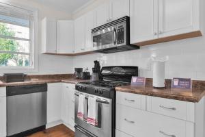a kitchen with a stove and a microwave at Ping-Pong & Huge Yard Central- Fayetteville Pearl in Fayetteville
