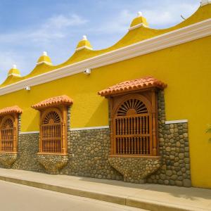 a yellow building with wooden windows on it at SGH Hotel San Agustin in Santa Marta