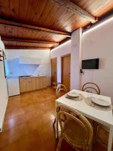 Una cocina y un comedor con una mesa y sillas blancas. en La Mignola casa vacanze, en Vieste